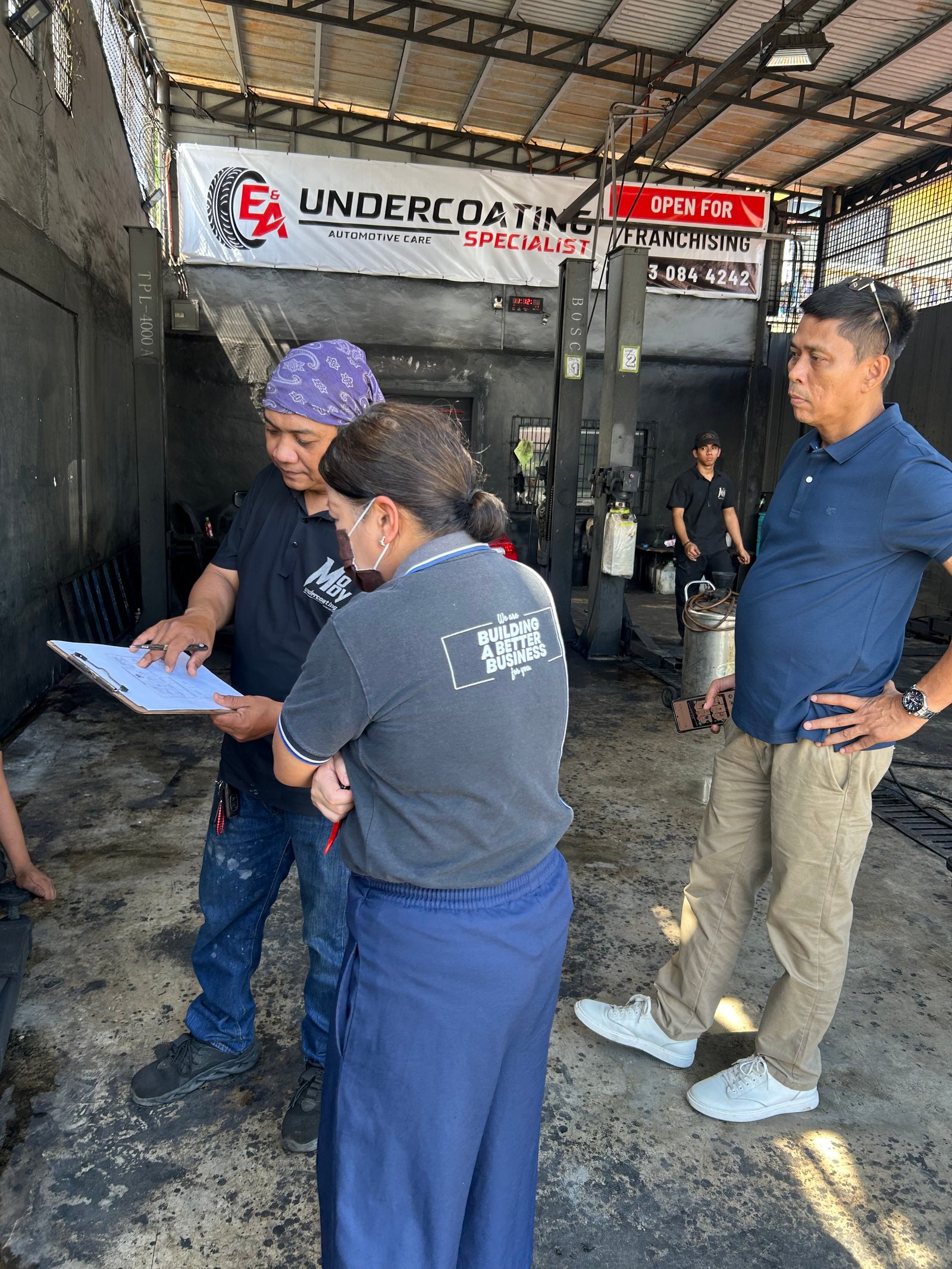 E&A specialist explaining vehicle undercoating to a customer